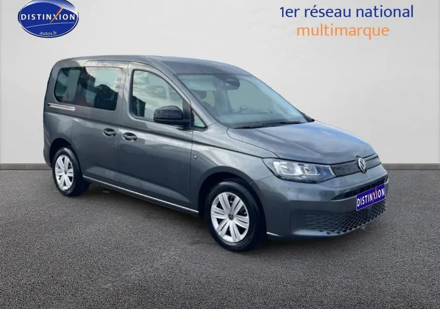 Volkswagen Caddy gris indien en 3/4 avant droit, avec vitres teintées et jantes alliage simples.