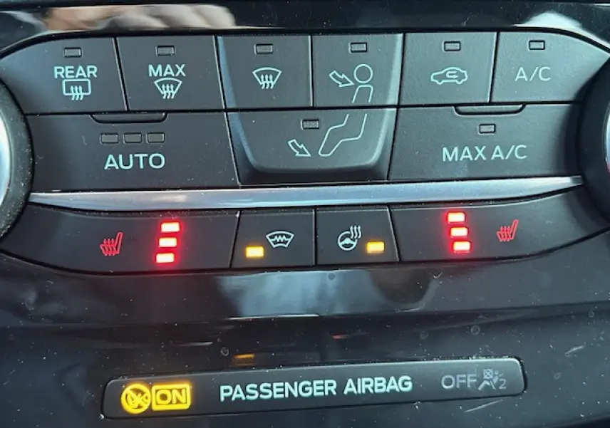 Gros plan sur la console centrale du Ford Puma gris Magnetic, affichant les commandes de climatisation et sièges chauffants.