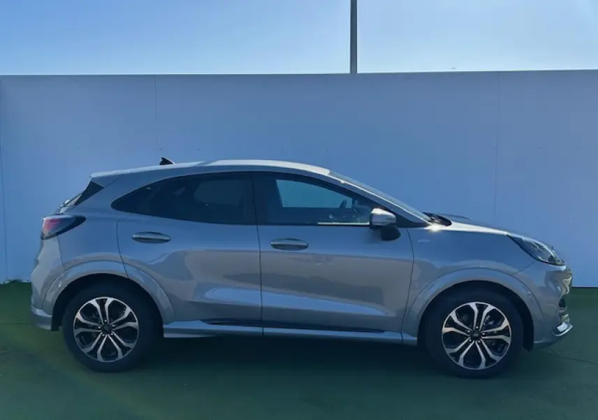 Ford Puma gris Magnetic vue de profil côté gauche, avec jantes alliage 17 pouces et vitres surteintées.