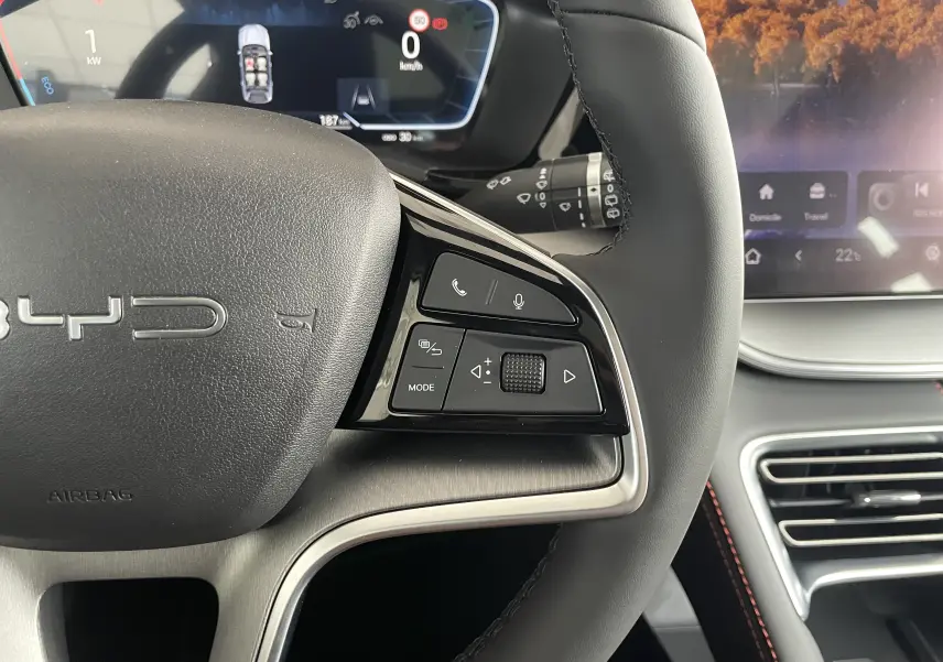 Gros plan sur le volant noir du BYD SEAL U 2025 avec commandes multifonctions et tableau de bord numérique en arrière-plan.