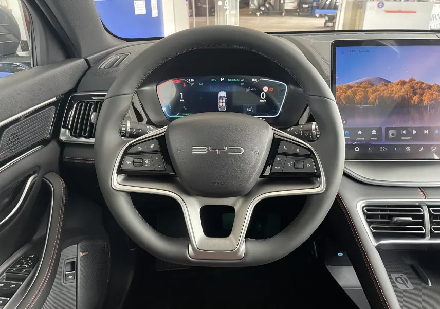 Vue intérieure centrée sur le volant BYD du Seal U 2025, avec tableau de bord numérique et écran tactile latéral.