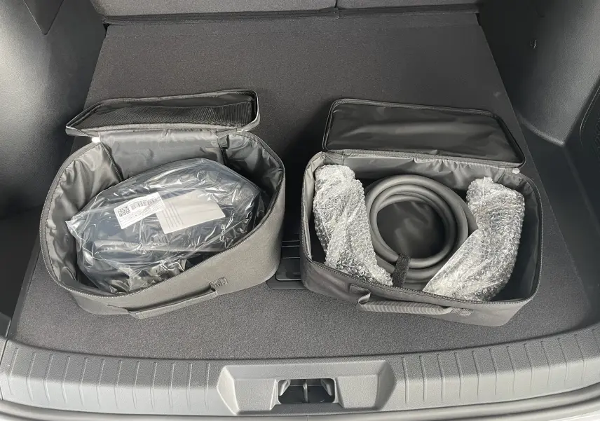 Vue plongeante sur le coffre du BYD SEAL U 2025 avec deux sacs de rangement contenant câbles de recharge.