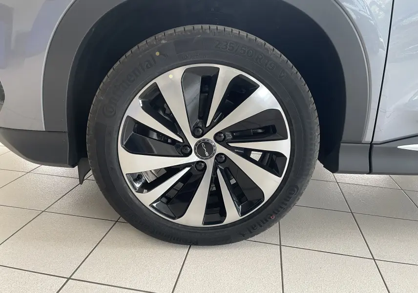 Gros plan sur la roue avant gauche du BYD SEAL U 2025 TIME GREY avec jante alliage bicolore 19 pouces.