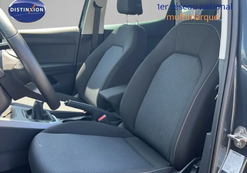 Vue intérieure côté conducteur du SEAT Arona gris Magnetic Metal, montrant les sièges en tissu gris à motifs discrets.