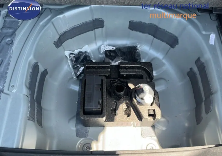 Coffre ouvert montrant le rangement gris métallique sous le plancher avec kit de réparation sur SEAT Arona 2025 toit blanc.