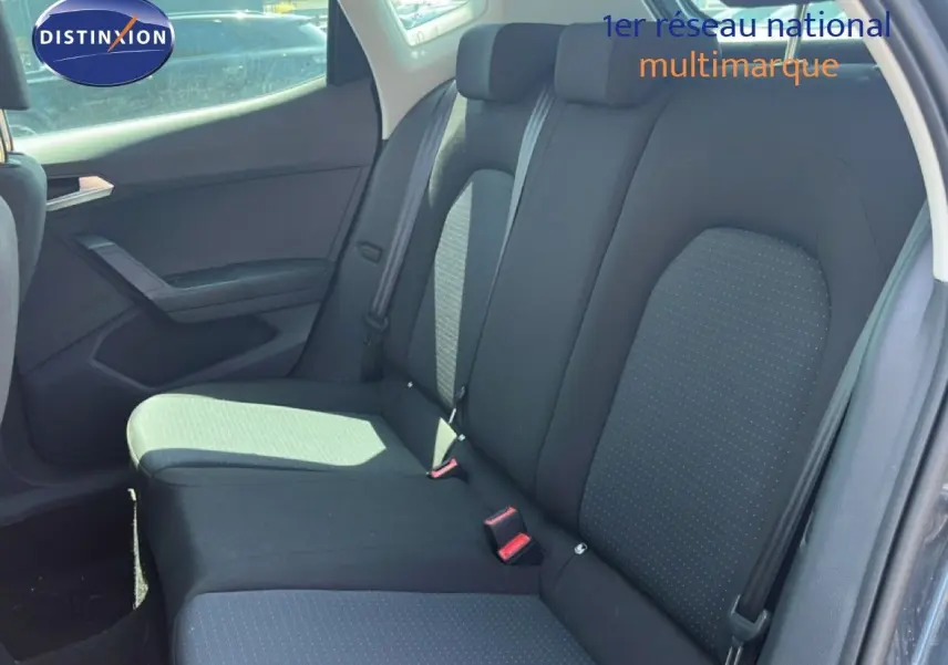 Vue intérieure des sièges arrière en tissu gris foncé du SEAT Arona 2025, avec ceinture de sécurité et porte côté gauche visible.