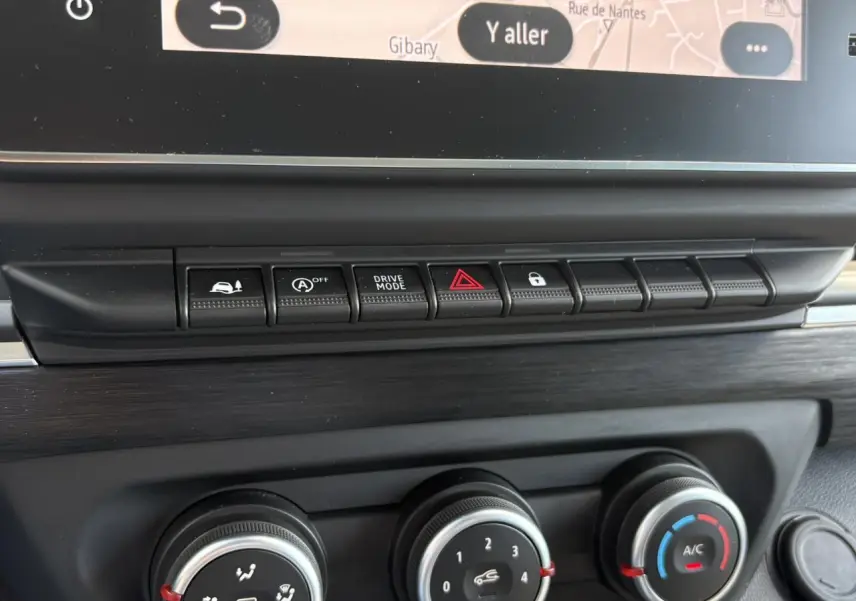 Gros plan sur la console centrale du Renault Trafic Fourgon Urban Grey 2024, montrant les commandes de climatisation et boutons fonctionnels.