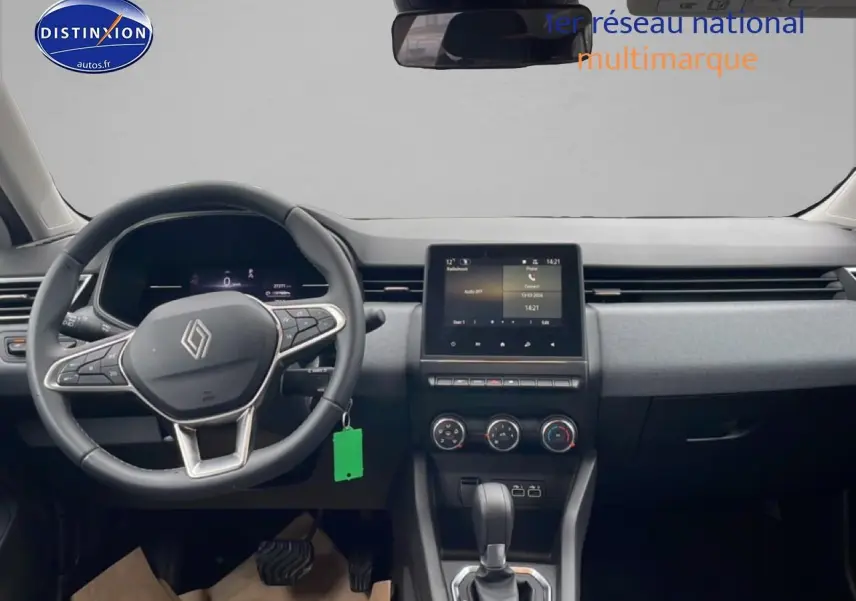 Vue intérieure frontale du tableau de bord et volant noir de la Renault Clio V blanche avec écran tactile central.