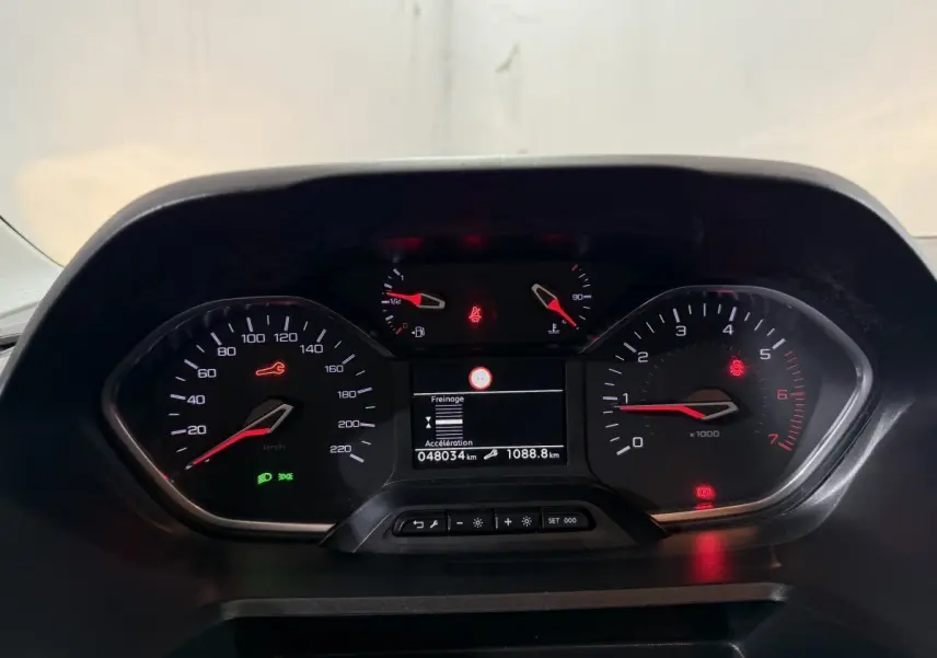 Vue rapprochée du tableau de bord du Peugeot Rifter blanc 2019, affichage digital et compte-tours visibles.