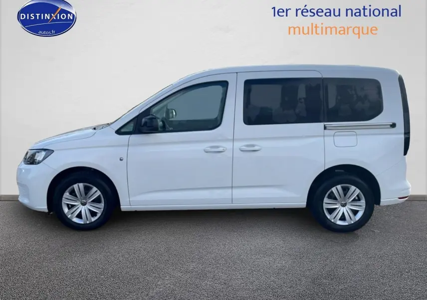 Profil droit d'un Volkswagen Caddy blanc 2025 avec vitres arrière teintées et jantes alliage.