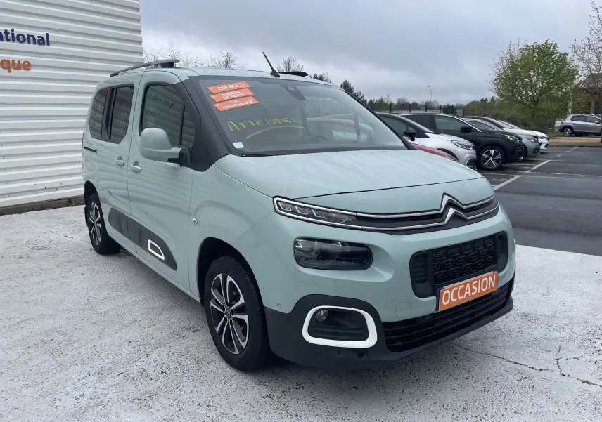 Citroën Berlingo vert clair en 3/4 avant droit, avec stickers orange "Diesel" et plaque "Occasion" visible.