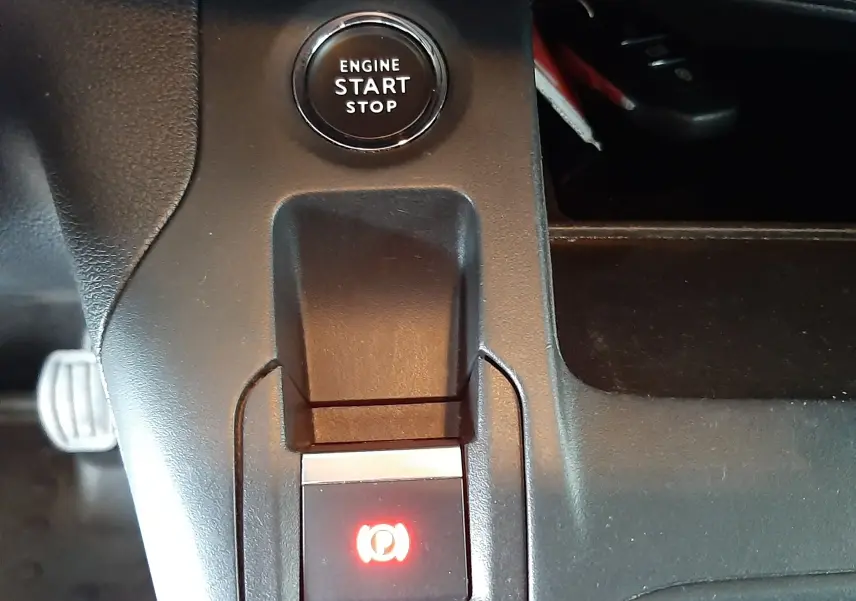 Détail intérieur du Citroën Berlingo 2019 montrant le bouton start/stop moteur et le frein à main électrique allumé.