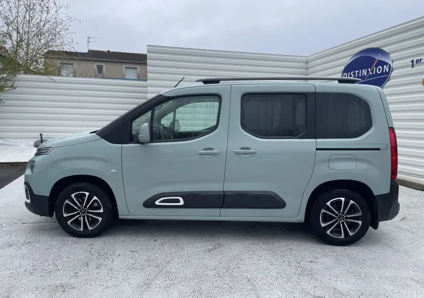 Vue de profil côté gauche d'un Citroën Berlingo M BlueHDi 130ch Shine vert clair avec jantes alliage et protections noires sur les portes.