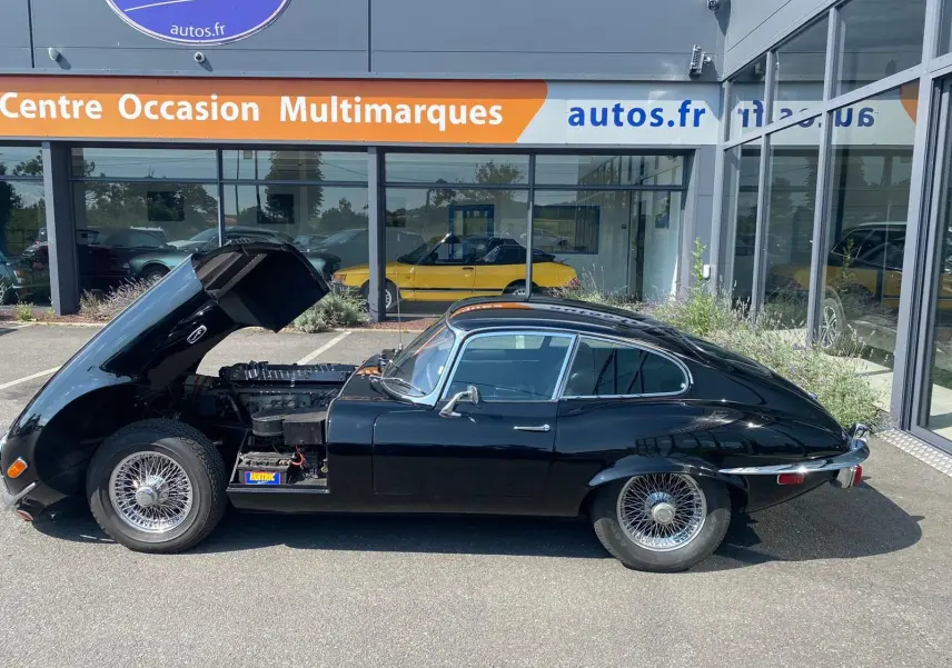 Profil côté gauche d'une Jaguar S-Type Type E Coupé 4.2 noire de 1970 avec capot avant ouvert dévoilant le moteur.