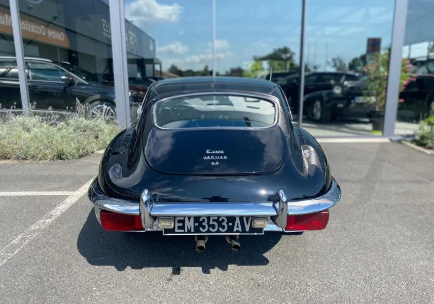 Vue arrière d'une Jaguar Type E Coupé 4.2 noire de 1970, avec ses doubles sorties d'échappement chromées visibles.