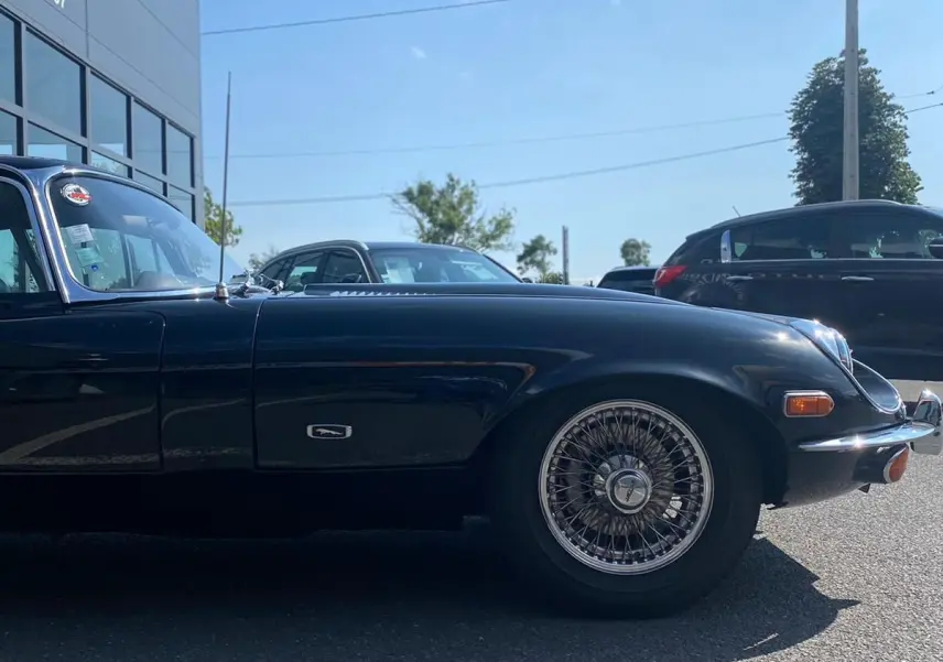 Profil côté gauche d'une Jaguar S-Type Type E Coupé 4.2 noire de 1970 avec jantes à rayons classiques.