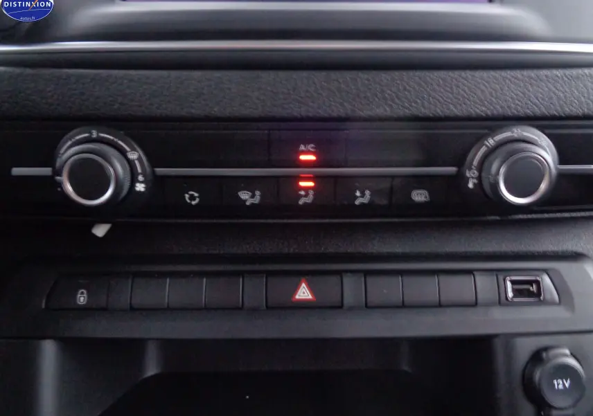 Gros plan sur la console centrale du Peugeot Expert Long 2023, avec commandes climatisation et boutons fonctionnels.