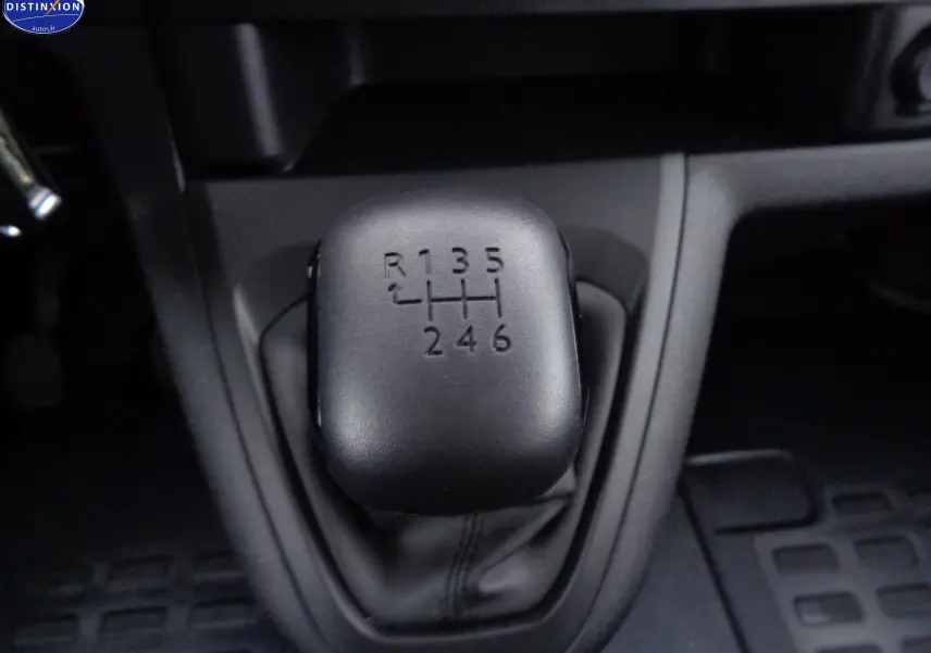 Gros plan sur le levier de vitesses manuel noir du Peugeot Expert Long 2023, montrant la grille des six rapports et la marche arrière.