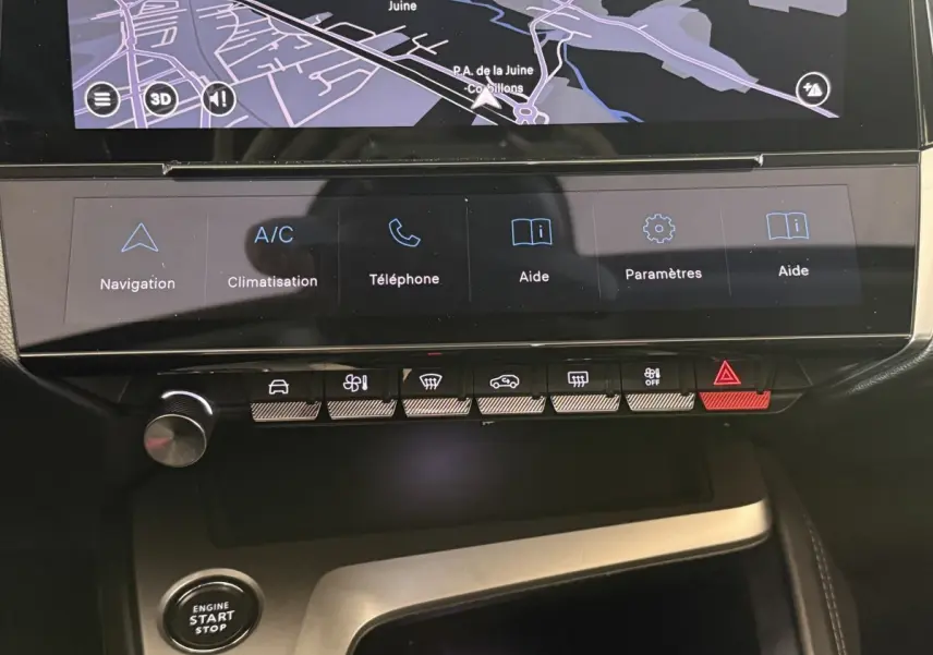 Vue rapprochée du tableau de bord tactile noir de la Peugeot 308 bleu 2023 avec commandes climatisation et navigation.