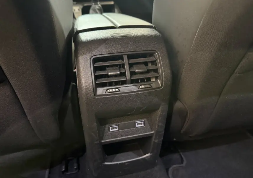 Vue rapprochée des aérateurs arrière et ports USB intégrés entre les sièges noirs d'une Peugeot 308 2023.
