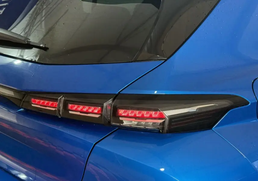 Gros plan sur le feu arrière droit rouge et noir d'une Peugeot 308 bleu 2023, soulignant la ligne moderne du hayon.