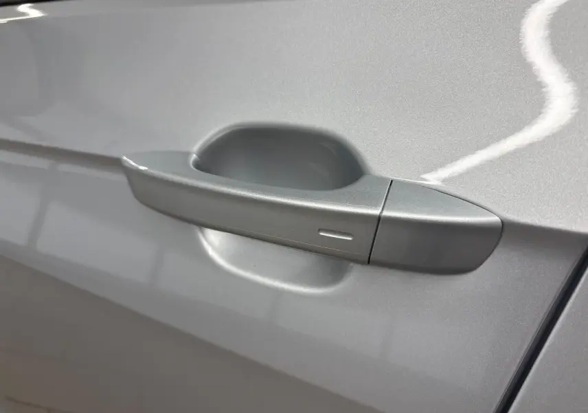 Poignée de porte côté gauche en reflet d'argent sur Volkswagen T-Cross 2024, finition VW Edition.
