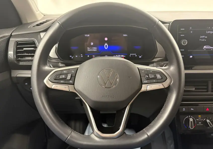 Vue intérieure centrée sur le volant cuir noir et le tableau de bord digital du Volkswagen T-Cross 2024.