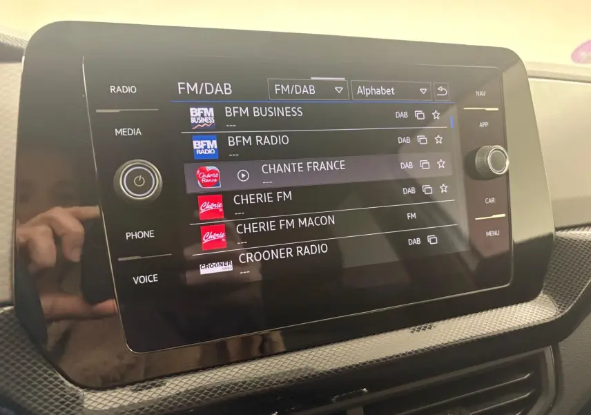 Écran tactile central affichant les stations radio FM/DAB dans l'habitacle du Volkswagen T-Cross 2024.