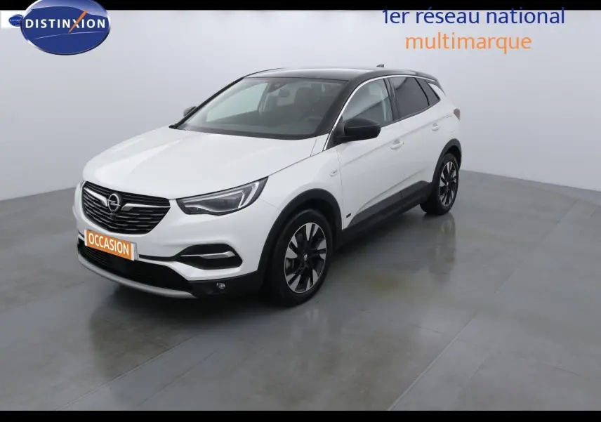 Opel Grandland X blanc nacré métal en 3/4 avant droit, toit noir et jantes alliage bicolores visibles.