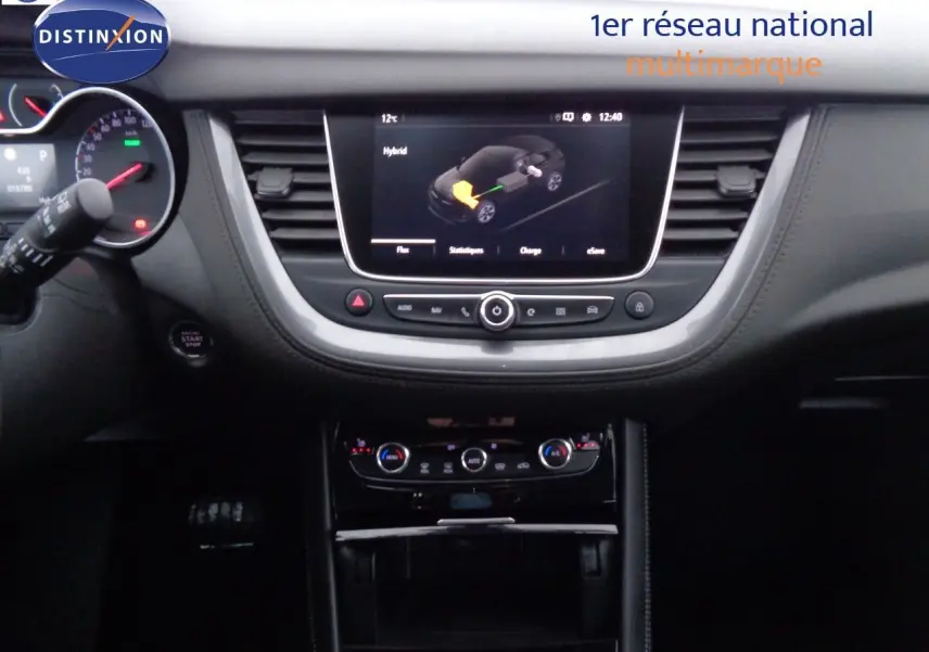 Vue intérieure centrée sur le tableau de bord du Opel Grandland X hybride, avec écran tactile affichant le mode hybride.