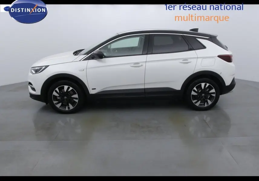 Vue latérale droite d'un Opel Grandland X blanc nacré avec jantes noires et toit noir contrastant.