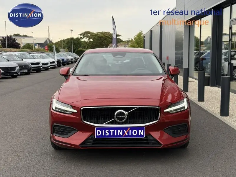 Vue frontale d'une Volvo S60 2.0 MHEV rouge fusion métallisé, avec calandre noire et phares LED distinctifs.