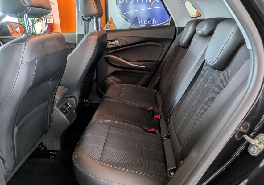 Vue intérieure côté droit des sièges arrière en cuir noir de l’Opel Grandland 2023 avec appuie-têtes et ceintures visibles.