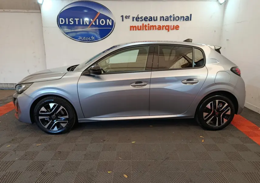 Profil droit d'une Peugeot 208 PureTech 100 S&S Allure gris clair, avec jantes alliage et vitres teintées.