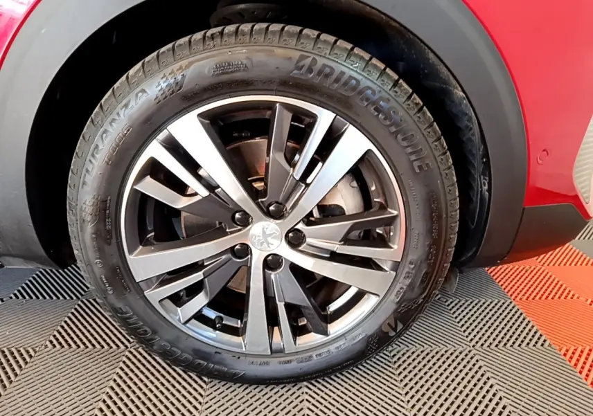 Gros plan sur l'arrière droit rouge du Peugeot 3008 1.6 Hybrid 225, avec passage de roue noir et jante visible.