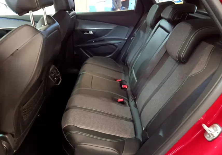 Vue latérale droite de la banquette arrière bi-matière grise et noire du Peugeot 3008 hybride rechargeable rouge.