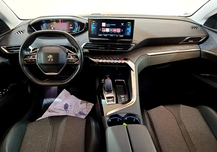 Vue intérieure avant du tableau de bord et volant cuir noir du Peugeot 3008 hybride rechargeable avec écran tactile central.