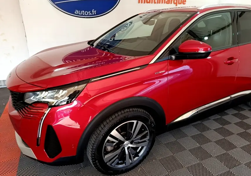 Vue 3/4 avant droit d’un Peugeot 3008 hybride rechargeable rouge avec jantes alliage et détails chromés.