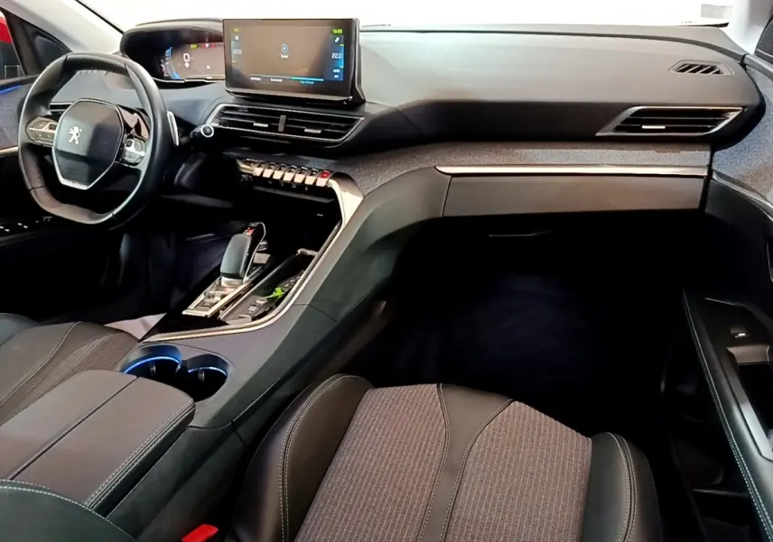 Intérieur noir et gris du Peugeot 3008 hybride, vue de côté droit sur le tableau de bord et console centrale avec écran tactile.