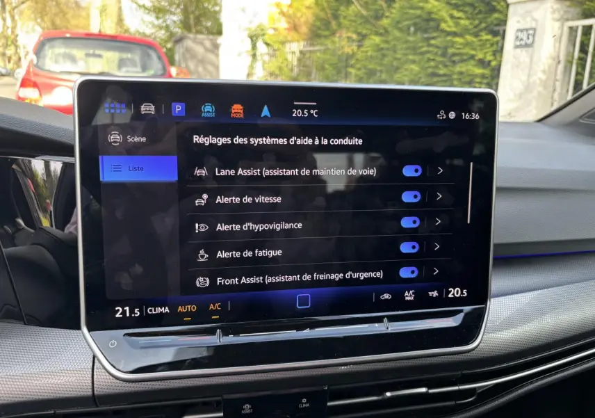 Écran tactile central de la Volkswagen Golf 2024 blanc, affichant les réglages des aides à la conduite.