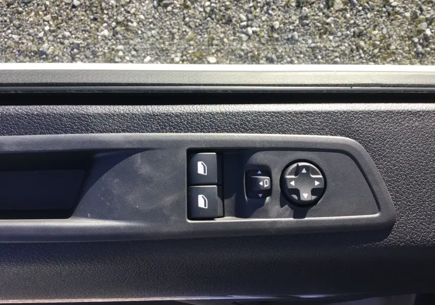 Gros plan sur les commandes de réglage des rétroviseurs et des vitres côté conducteur du Peugeot Expert Fourgon blanc 2024.