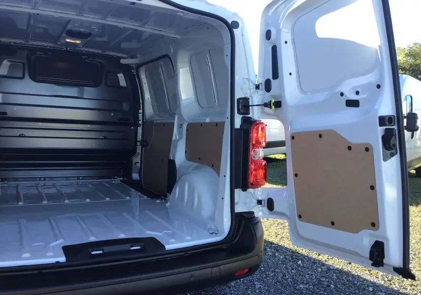 Vue arrière ouverte du Peugeot Expert Fourgon blanc 2024, montrant l'espace de chargement vide et les portes arrière battantes.