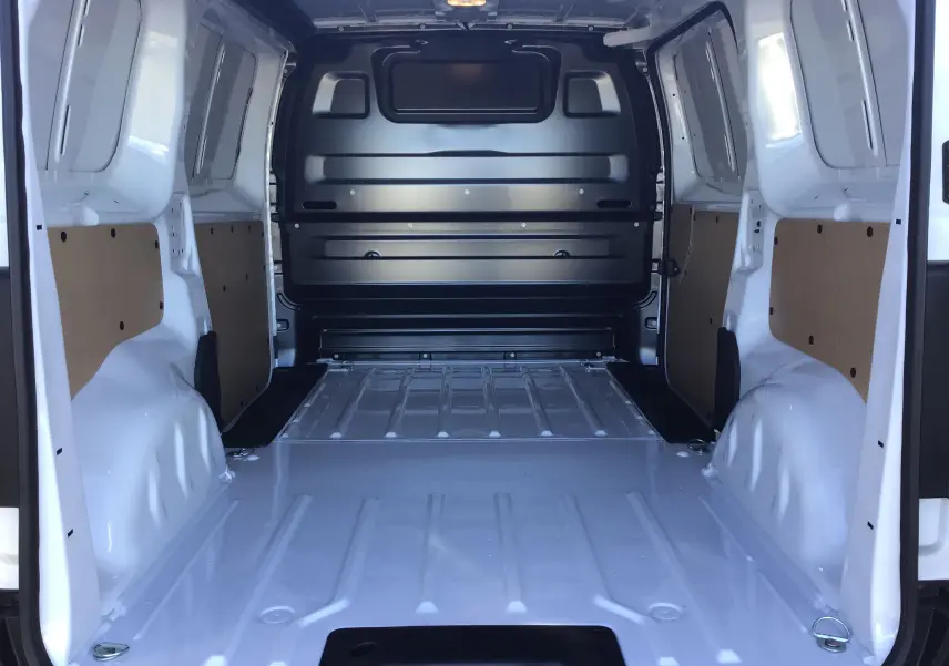 Vue intérieure arrière du fourgon blanc Peugeot Expert avec plancher métallique et parois partiellement protégées.