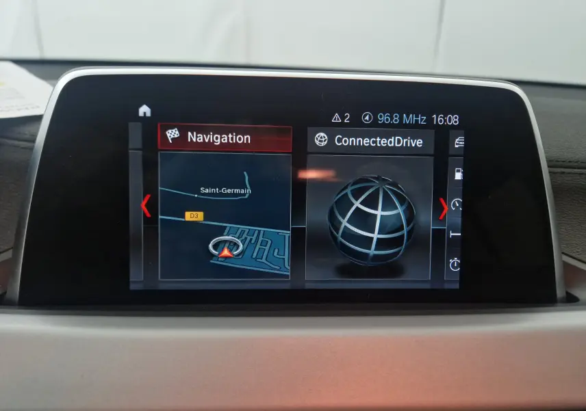 Écran de navigation multimédia business de BMW X2 gris clair, affichant carte et menu ConnectedDrive.