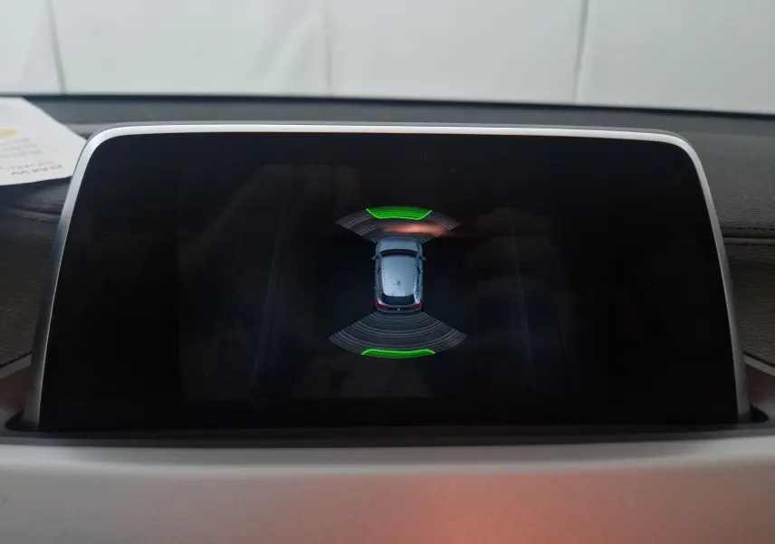 Écran de la BMW X2 gris clair montrant l'affichage du système d'aide au stationnement vue de dessus.