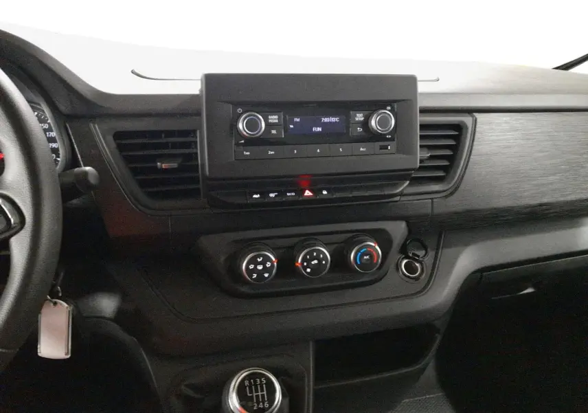 Tableau de bord et console centrale du Renault Trafic Fourgon blanc, vue intérieure côté conducteur avec commandes manuelles.