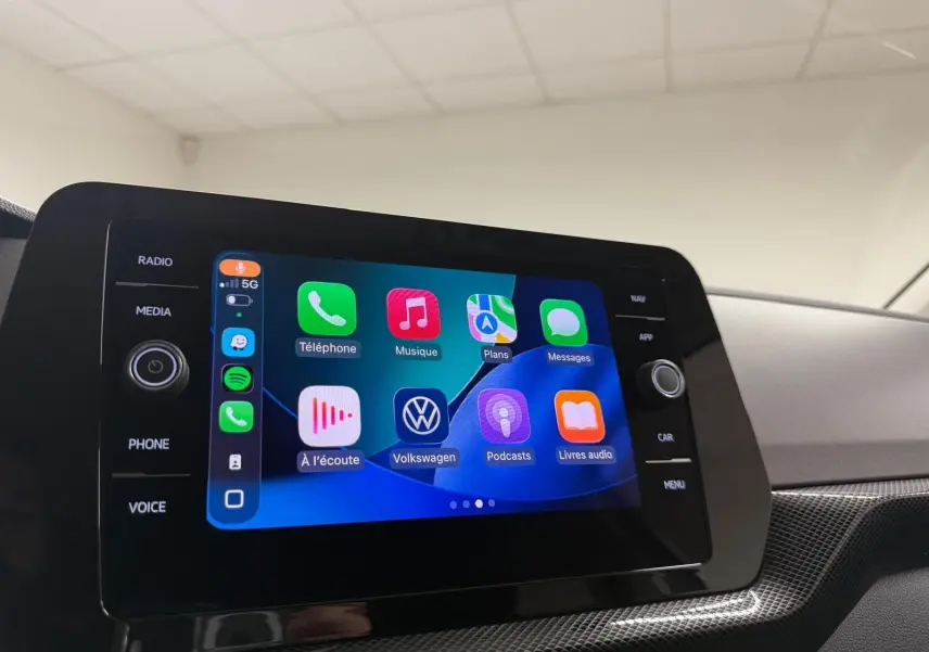 Écran tactile central du Volkswagen T-Cross 2025 affichant l’interface Apple CarPlay avec icônes colorées.