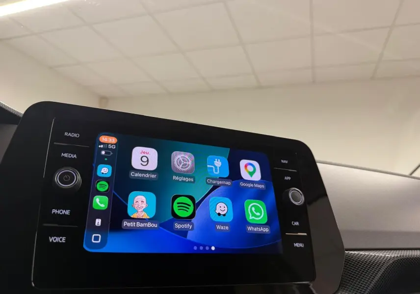 Écran tactile central du Volkswagen T-Cross 2025 affichant plusieurs applications, intérieur gris cendre visible en arrière-plan.