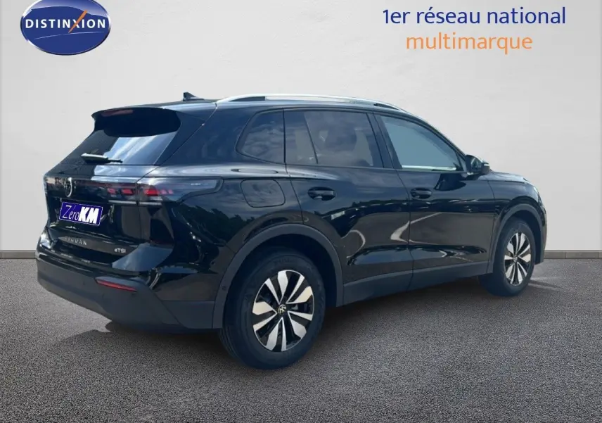 Volkswagen Tiguan noir grenadilla métal en 3/4 arrière droit, SUV hybride essence avec jantes spécifiques.