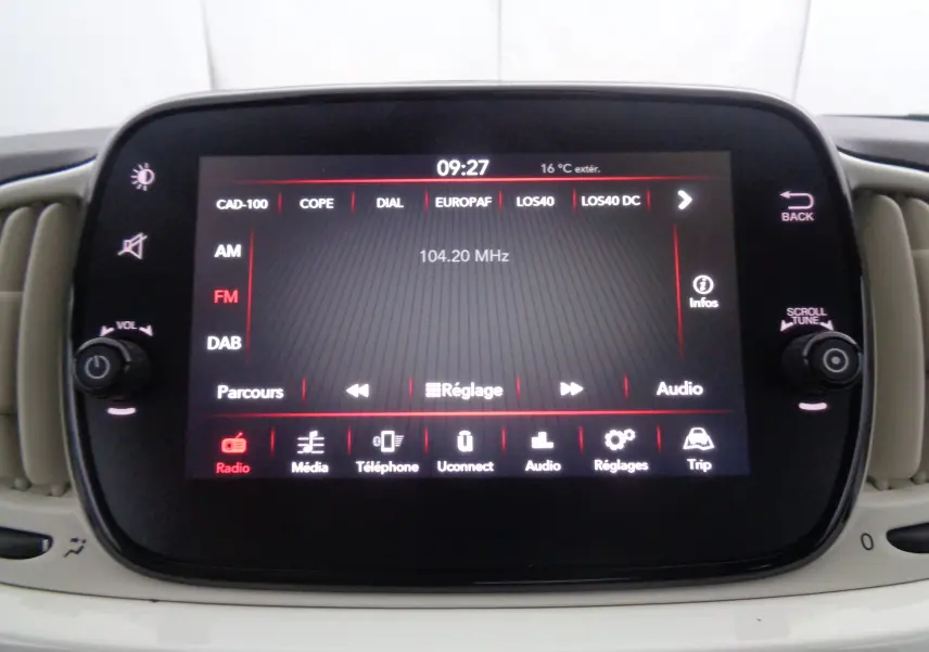 Écran tactile central de la Fiat 500 blanc gelato affichant la radio FM à 104,20 MHz avec commandes tactiles visibles.